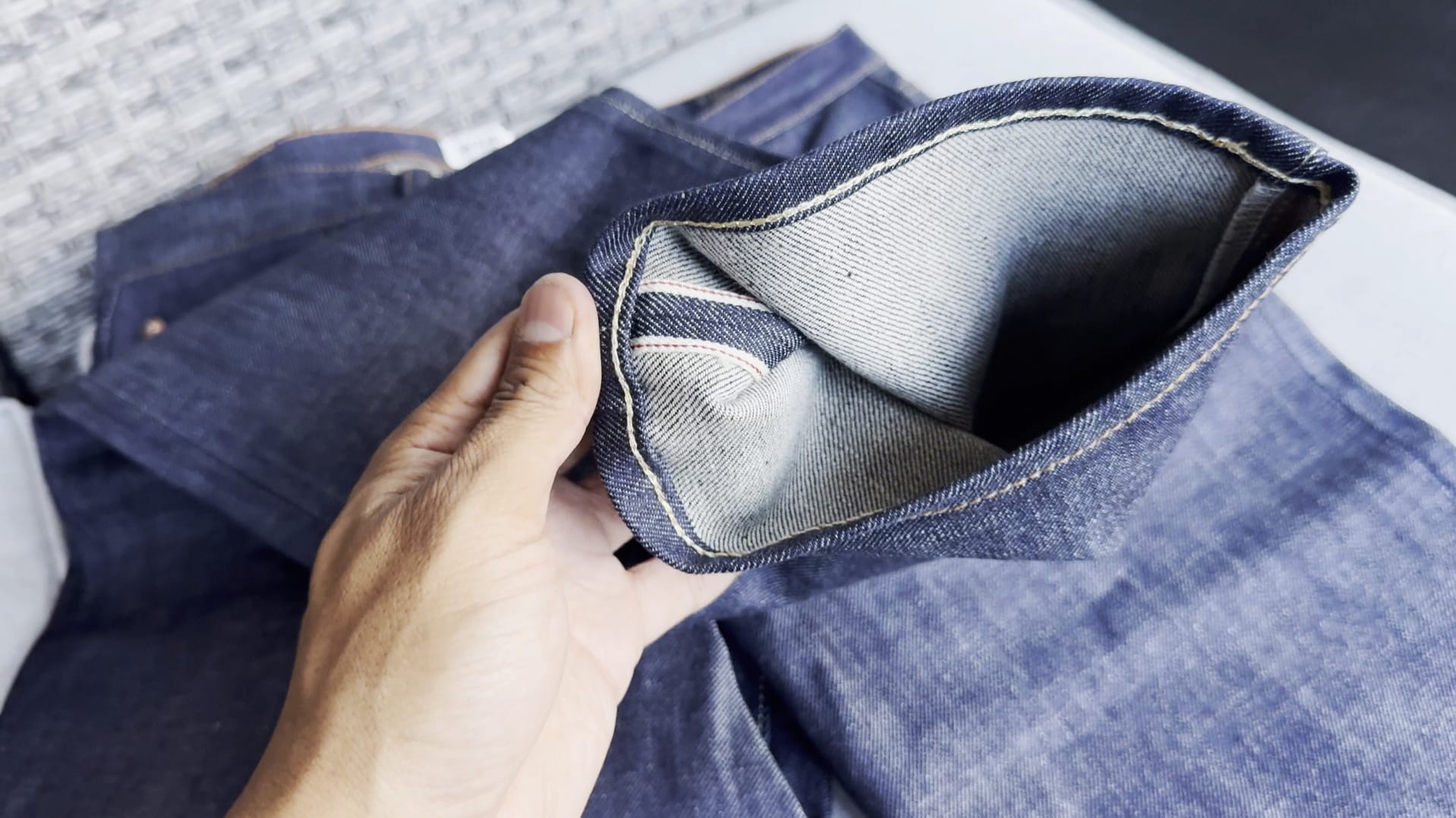Holding the hem of Weirloom jeans