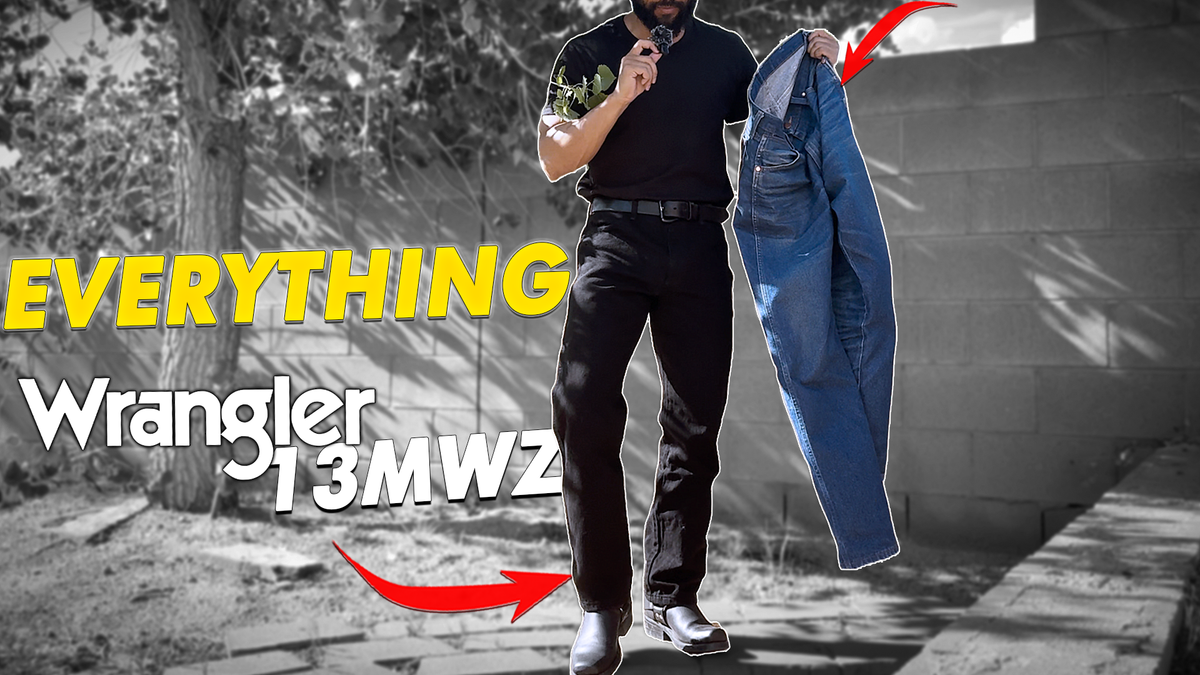 Holding up a pair of rigid indigo Wrangler 13MWZ while wearing a Shadow Black pair