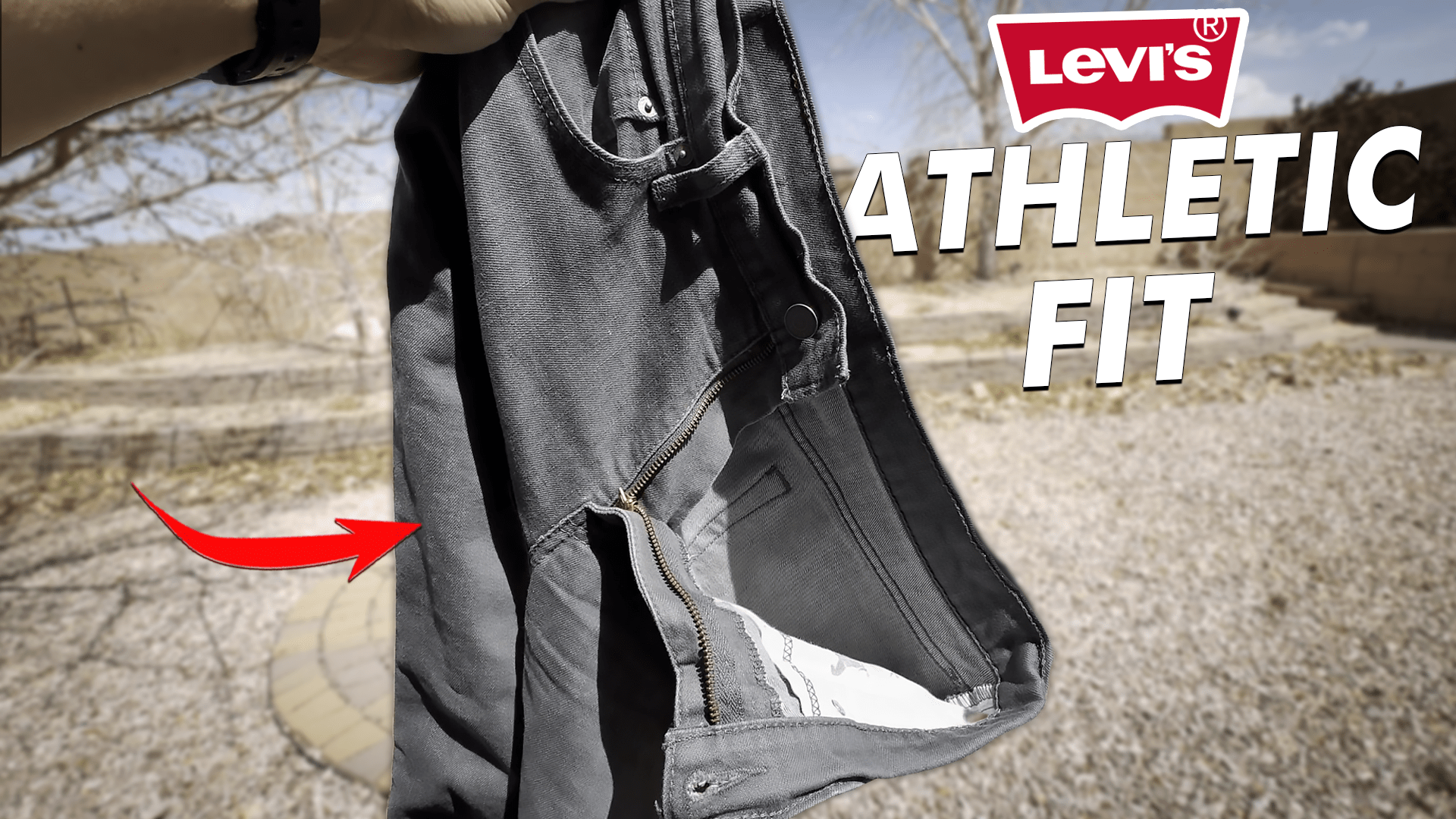 Holding up a pair of raw gray Levi's 541 athletic fit denim jeans
