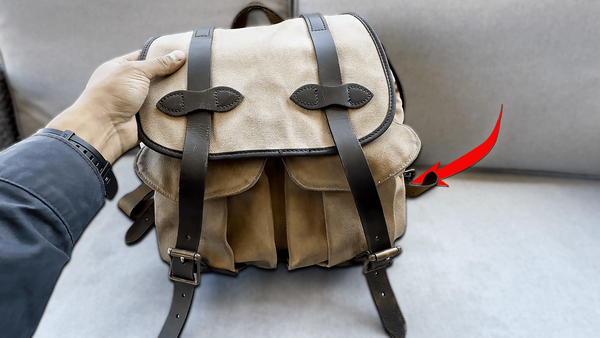 Holding a Filson rugged twill rucksack