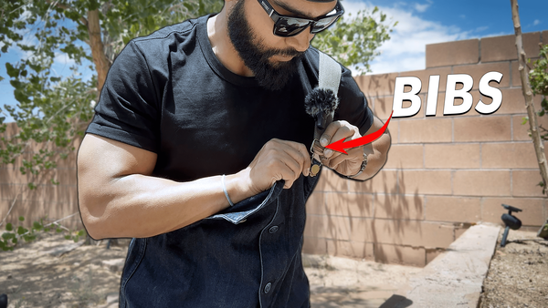 Undoing the brass hook on a pair of denim overalls