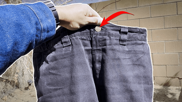 Holding up a pair of well-used Vertx Phantom tactical pants in black